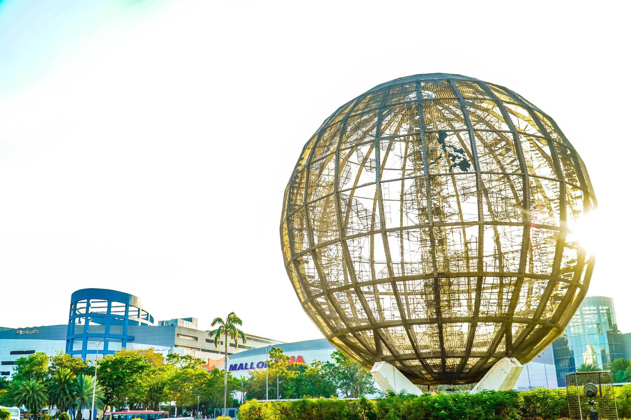 SM Mall of Asia Globe and shopping complex under a bright blue sky in Pasay City, Metro Manila, Philippines.