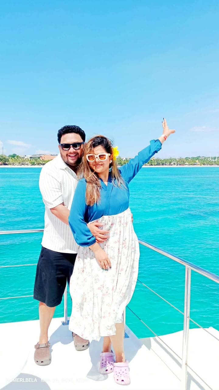 Couple enjoying a yacht cruise surrounded by turquoise waters in Boracay, Philippines.